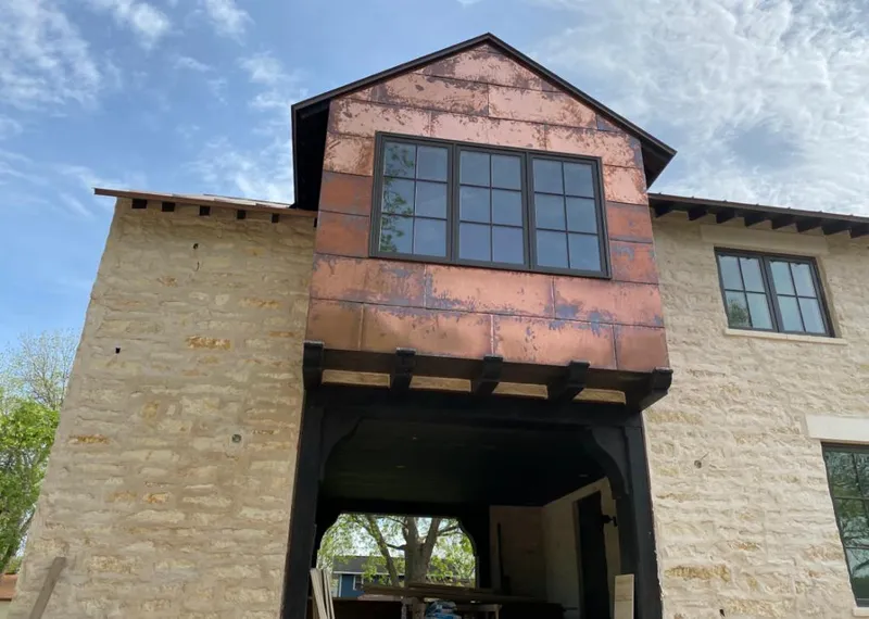 Copper metal panel facade on a stone building for Skylight Installation in Kennett